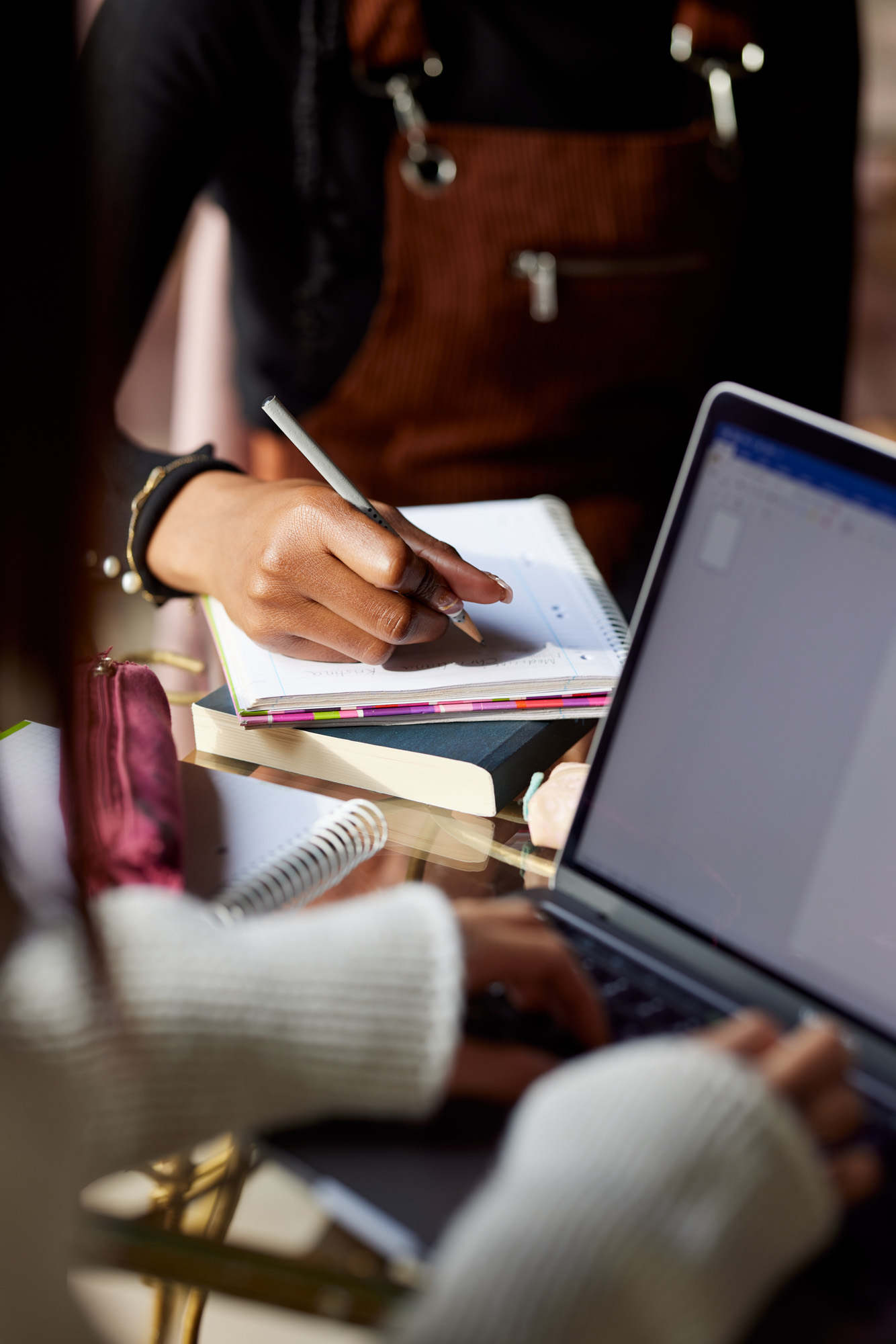 Close up of a multicultural student's hand writes tasks in a tex